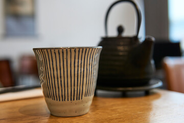 Asian teapot and cup on a restaurant table. Black teapot