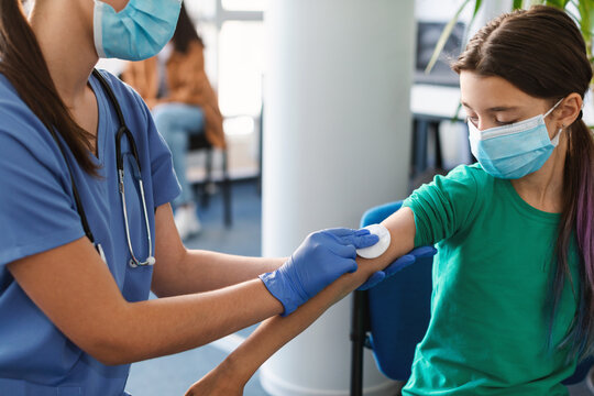 Teen Patient Preparing To Get Vaccinated, Doctor Disinfecting Skin