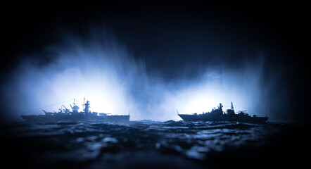 Silhouettes of a crowd standing at blurred military war ship on foggy background. Selective focus....