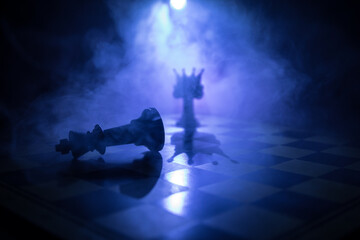 chess board game concept of business ideas and competition and strategy ideas concep. Chess figures on a dark background with smoke and fog and window with sunlight. Selective focus