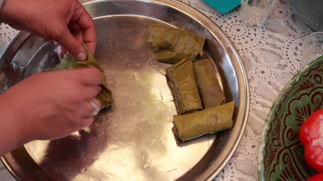People cook dolma food.
Grape leaves stuffed with minced meat.