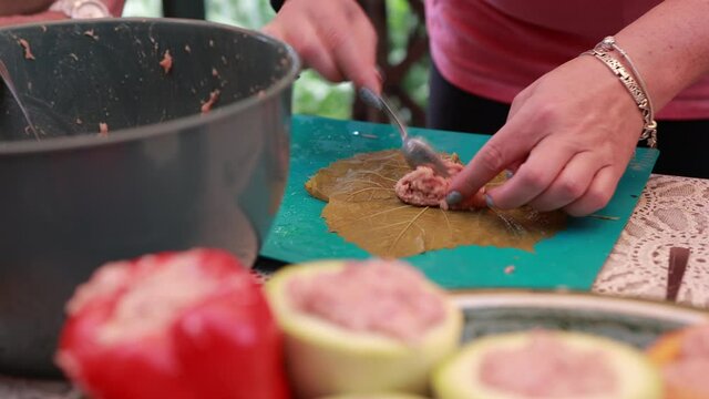 People cook dolma food.
Grape leaves stuffed with minced meat.