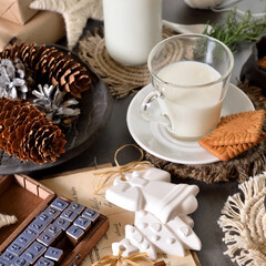 a plate wirh  cookies and a glass of milk on a table decorated with Christmas decor