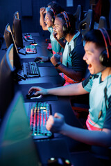 Competitive gamers playing and winning in online video game on high-powered game computers in cyber...