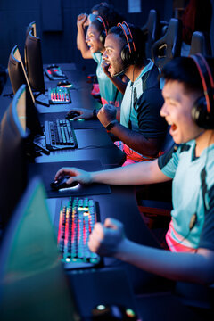 Competitive gamers playing and winning in online video game on high-powered game computers in cyber club