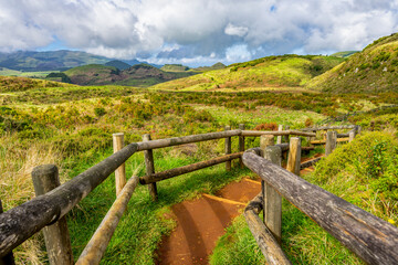 Fototapeta Pieszy szlak po polach siarkowych, zabezpieczony drewnianym ogrodzeniem Furnas De Enxofre, Terceira, Azores, Portugalia obraz