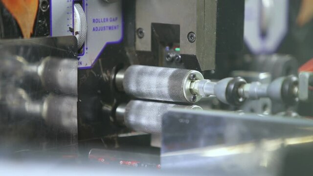 Cutting an electrical cable by a machine in production.