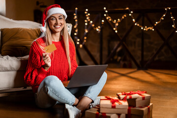 Xmas Shopping. Smiling woman using laptop showing credit card