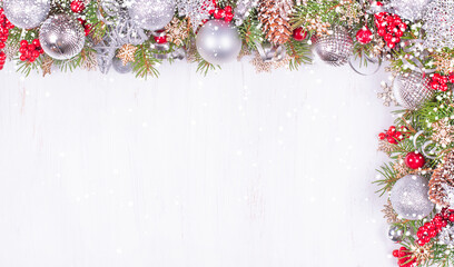 Fototapeta na wymiar Christmas Card. Fir Branches, Silver Balls and Snowfall on Holiday Background