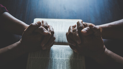 Couple are pray together on a Holy Bible