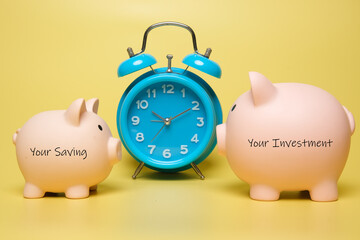 A picture of two piggybank written your investment and your saving with alarm clock. Your...