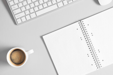 Gray office desk mockup, open notepad, coffee cup, computer keyboard.Flat lay, top view, copy space