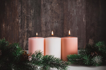 Christmas background, three burning candles, Christmas tree and gift on dark wood background