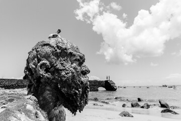 Portrait of a man's face covered in oil against the sea.