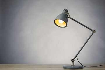 desk lamp on the table, gray background with copy-space