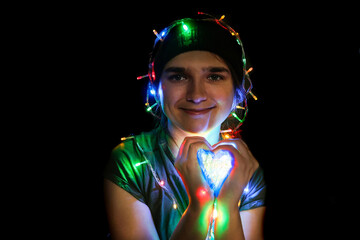 Portrait of a festive young woman with garland on her head and body. Bokeh and lights. Girl 25...