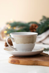 Obraz na płótnie Canvas Tea cup with festive background of pine branches and pine cones. Christmas celebration.