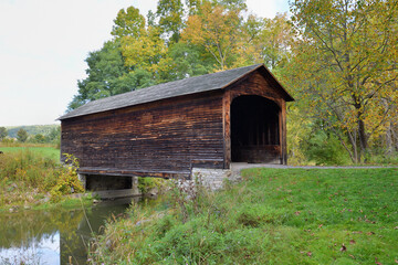 The Hyde Hall Covered Bridge over Shadow Brook in New York's Glimmerglass State Park. The bridge...