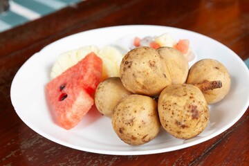 Mixed fruit plate on white brown table