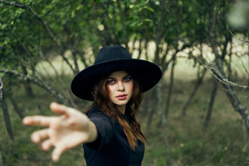 woman in a black hat gesturing with her hands witch magic fantasy