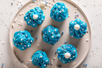 Beautiful cupcakes made of sprinkles and blue cream.