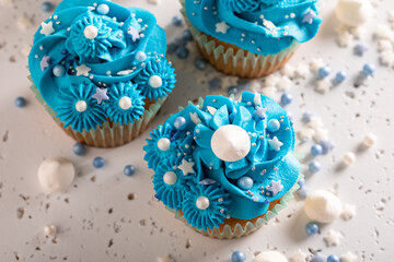 Sweet cupcakes with blue whipped cream ready to eat.