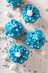 Delicious cupcakes with blue whipped cream ready to eat.