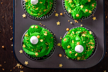 Delicious green cupcakes with sprinkles and made for the Christmas.