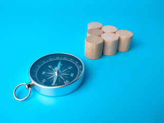 Block cylinder and compass on a blue background. with copy space.