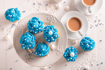 Sweet blue cupcakes made of white sprinkles and cream.