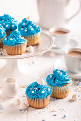 Beautiful blue cupcakes with cream and sprinkles for fat thursday.