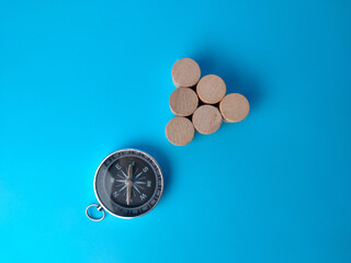 Block cylinder and compass on a blue background. with copy space.