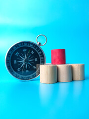 Block cylinder and compass on a blue background. with copy space.