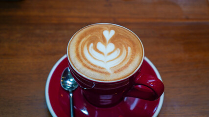 Cappuccino coffee with red cup and flower topping