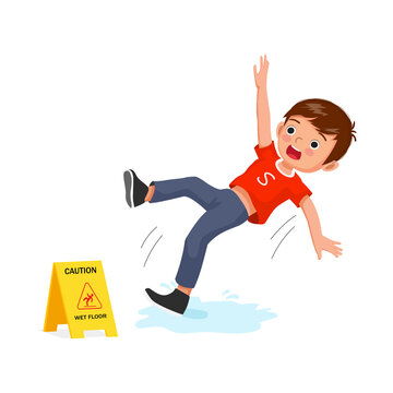 Cute little boy having accident slipping on wet floor and falling down near yellow caution sign.