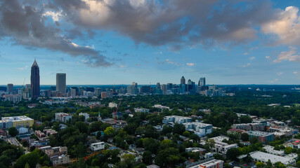 Fototapeta na wymiar a stunning aerial shot of the cityscape at sunset with skyscrapers surrounded by blue sky and powerful clouds and lush green trees in Atlanta Georgia USA