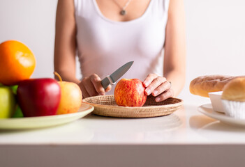 Obraz na płótnie Canvas Woman hands holding red apple and knife on white background,Healthy diet,Dieting concept