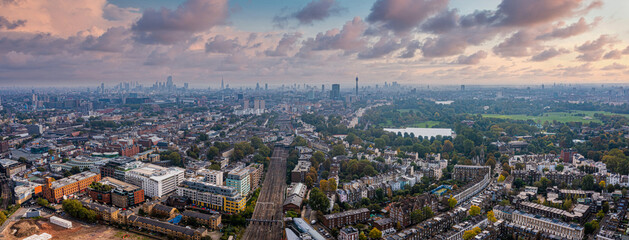 Obraz na płótnie Canvas Beautiful aerial view of London with many green parks and city skyscrapers in the foreground.