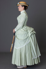 A Victorian woman wearing a tennis ensemble