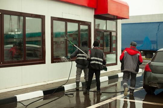 Workers wash windows outside. Cleaning of store windows.