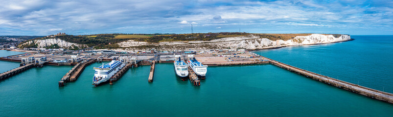 Aerial view of the Dover harbor with many ferries and cruise ships entering and exiting Dover, UK. - obrazy, fototapety, plakaty