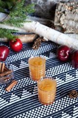 Apple spiced cider served on ice with apple and cinnamon