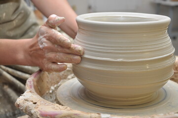 Fototapeta na wymiar creating a clay vase on a potter's wheel close-up