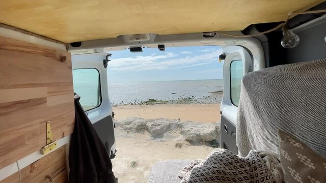 Static view of the ocean immensity form a van opened. Daylight. Van Conversion for traveling.