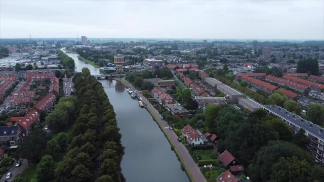 Aerial shot of boat on river flowing through city in the Netherlands