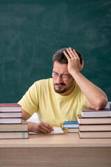 Young male student preparing for exams in the classroom