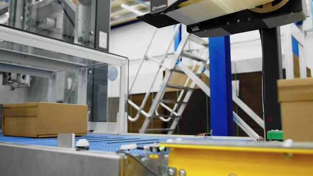 Machine automatically puts labels on boxes; automated packaging