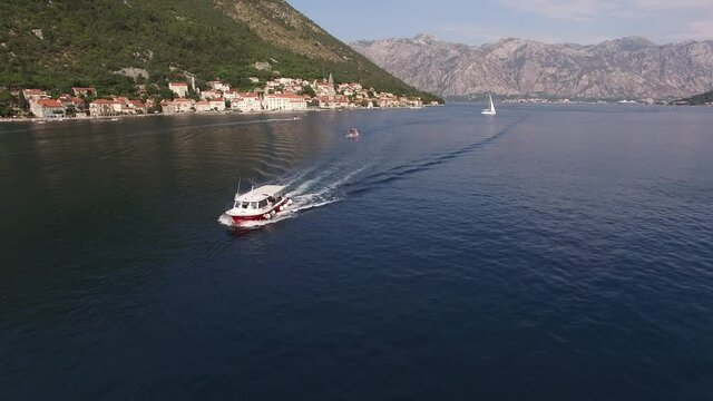 Tourist boat sails along the Bay of Kotor with the mountains in the background. Montenegro