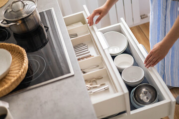 Top view modern housewife tidying up kitchen cupboard during general cleaning or tidying up