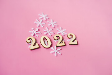 Pink pastel flatlay with snowflakes and wooden eco-friendly Christmas and New Year 2022 decorations